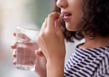 Cropped shot of an unrecognizable teenage girl drinking medication