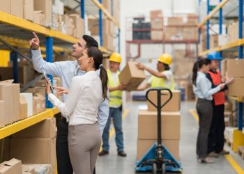 Group of people working at a distribution warehouse - freight transportation concepts