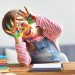 happy funny child girl draws laughing shows hands dirty with paint